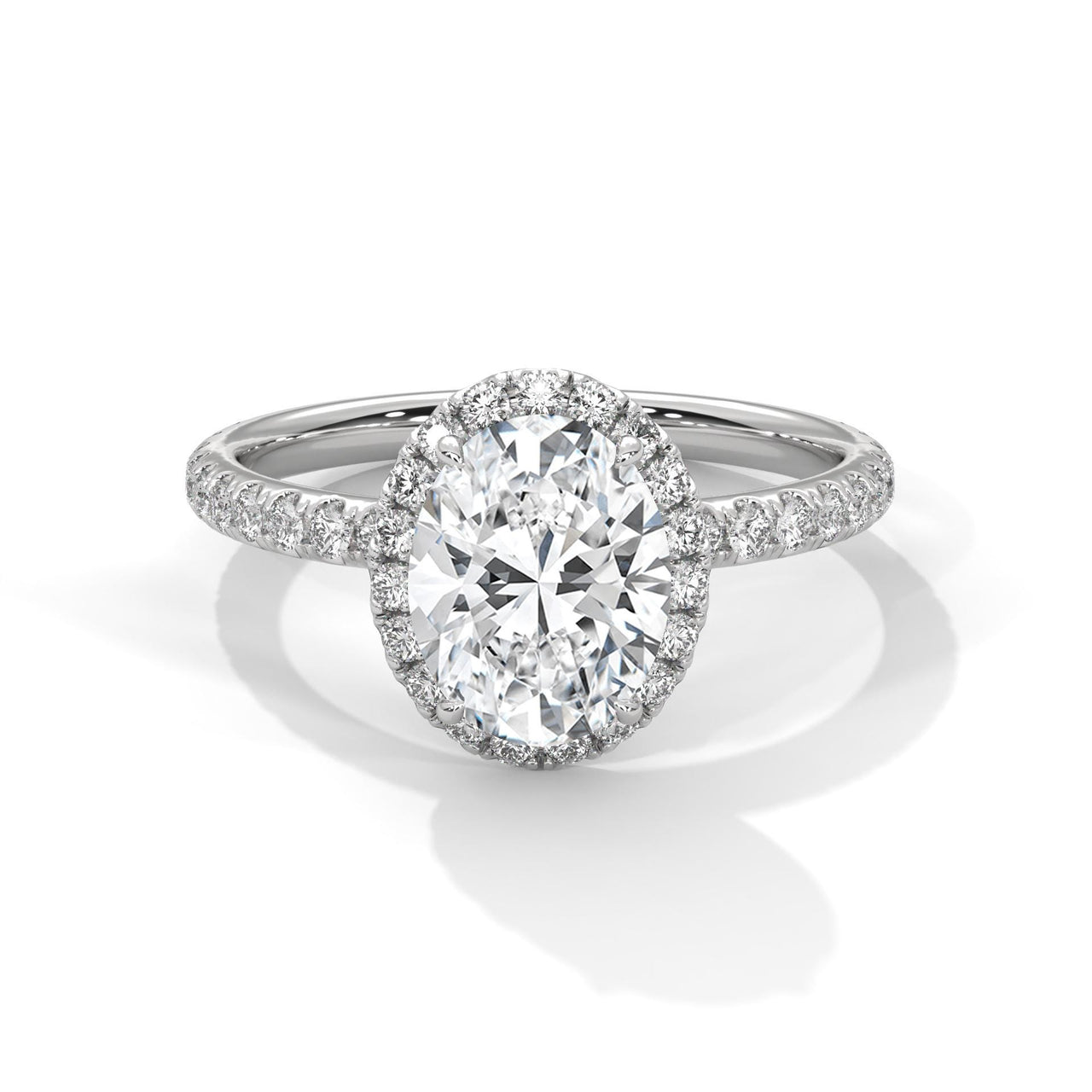 White gold oval halo engagement ring featuring a shimmering pavé diamond shank