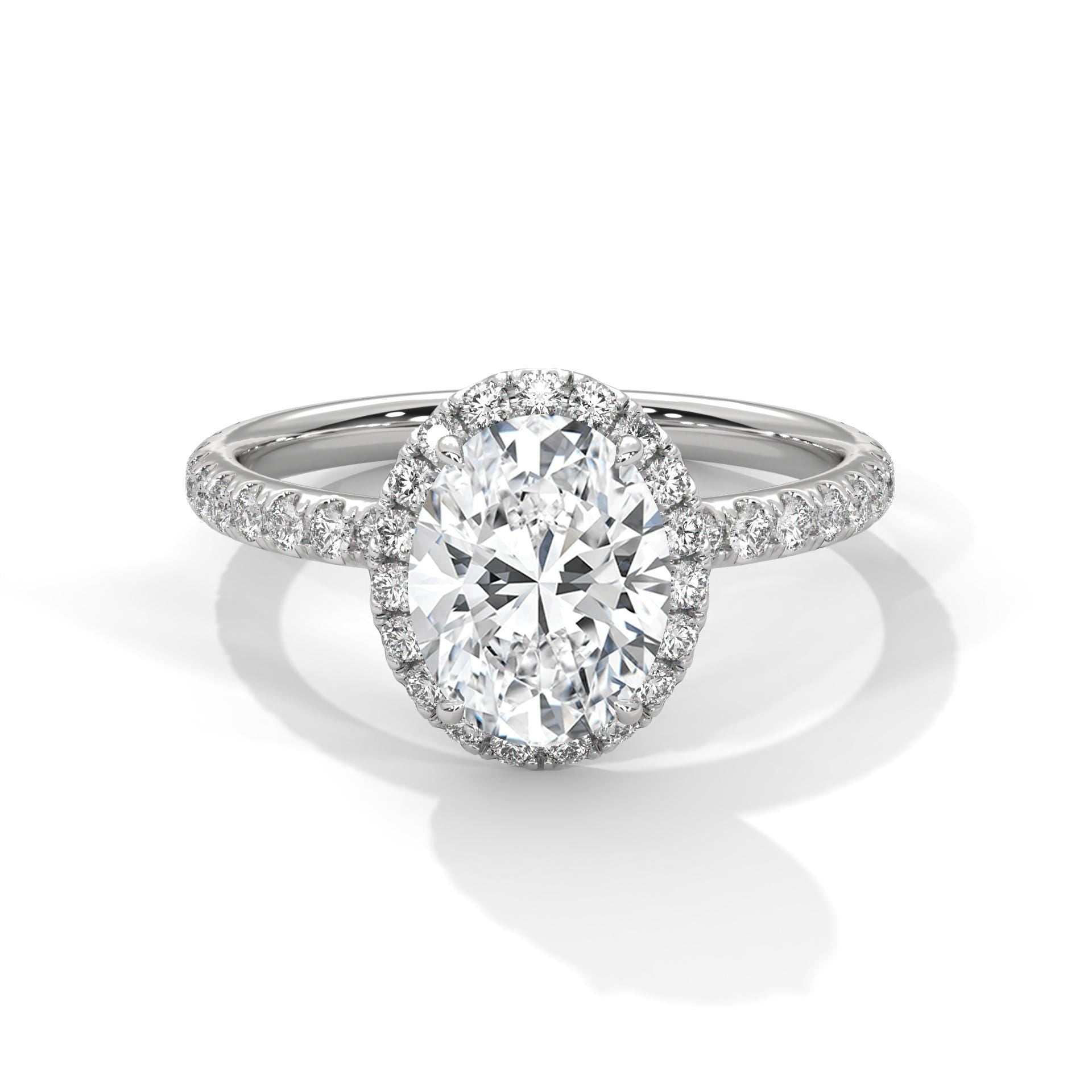 White gold oval halo engagement ring featuring a shimmering pavé diamond shank