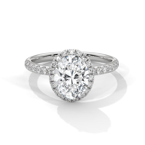 White gold oval halo engagement ring featuring a shimmering pavé diamond shank