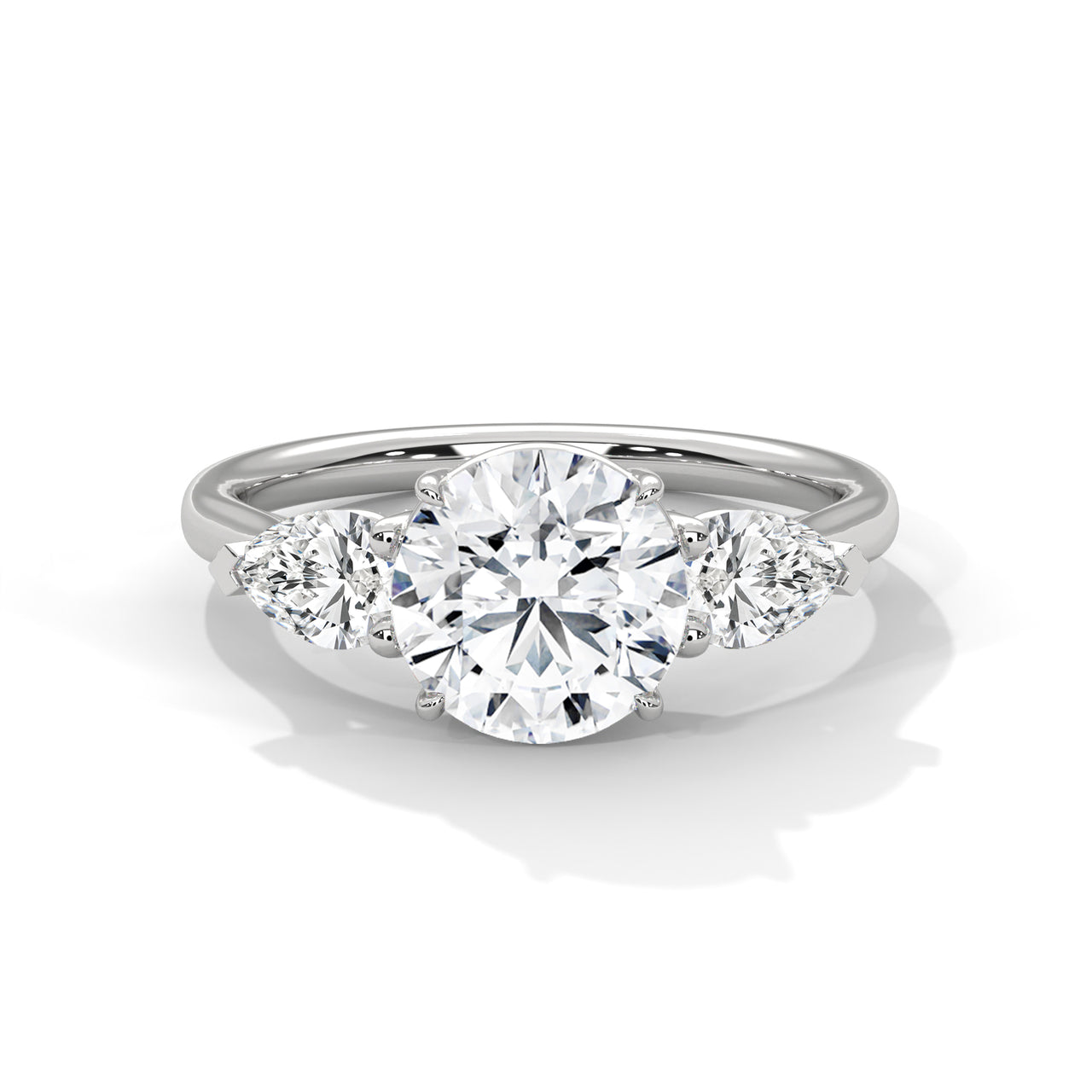 Three-stone lab-grown diamond engagement ring with round center and pear side stones in white gold.