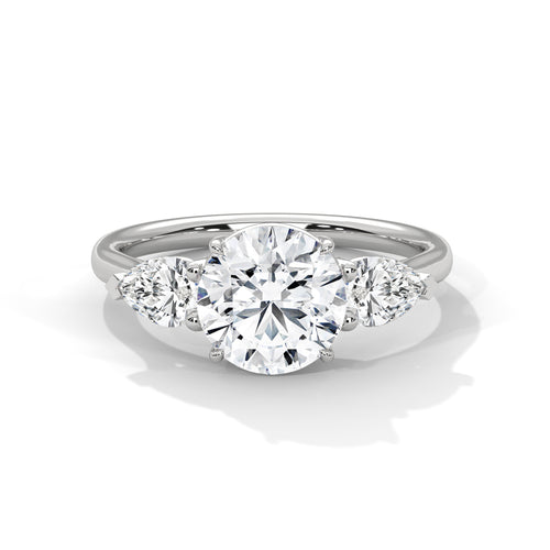 Three-stone lab-grown diamond engagement ring with round center and pear side stones in white gold.