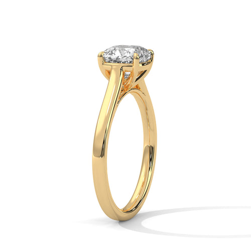 Angled perspective of a cushion cut solitaire ring in yellow gold highlighting the light-reflective sloped band.