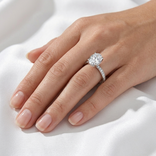 Oval hidden halo micropavé engagement ring in white gold worn on hand, close-up view