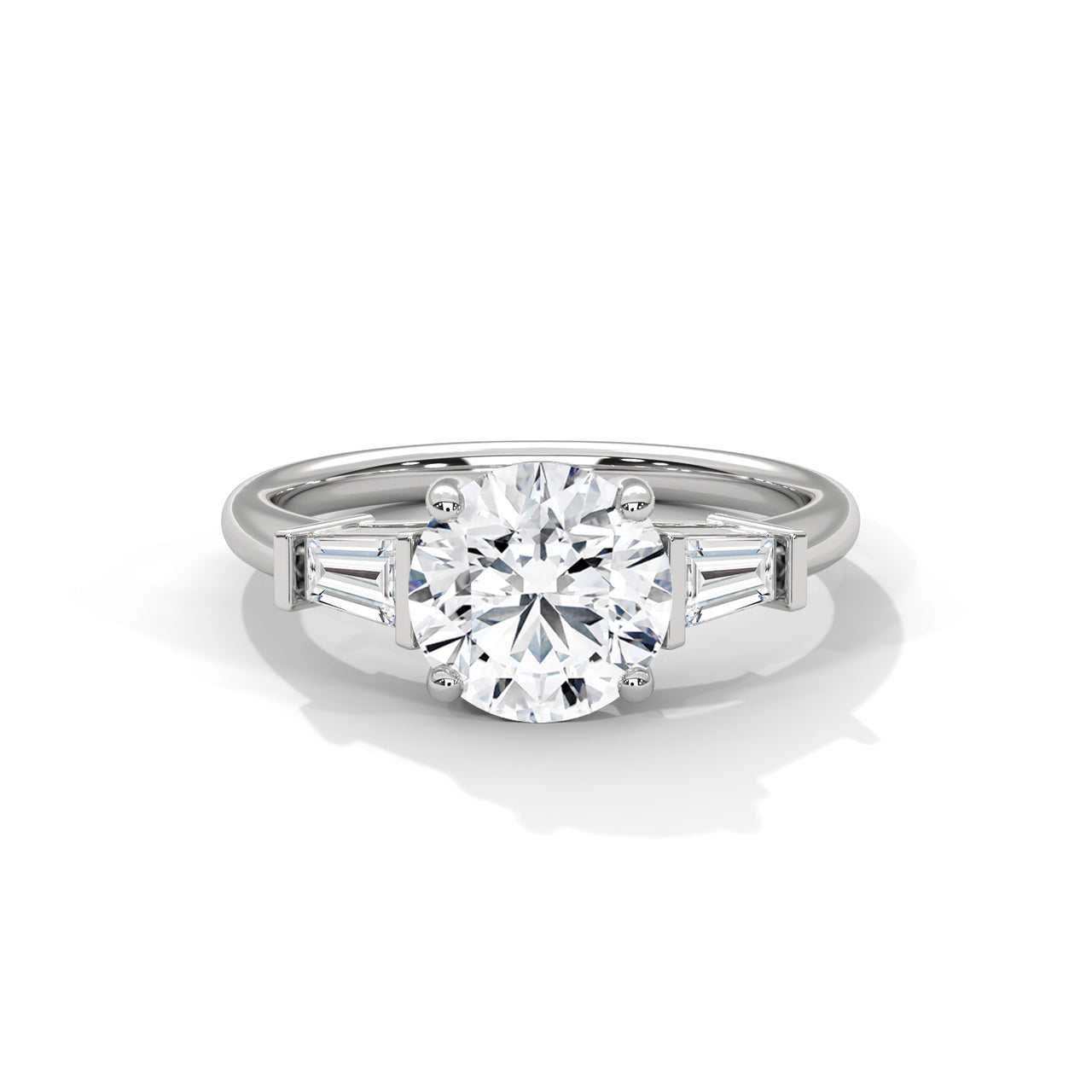 Front view of a solid white gold three-stone engagement ring showcasing a brilliant round center diamond and two tapered baguette side stones.