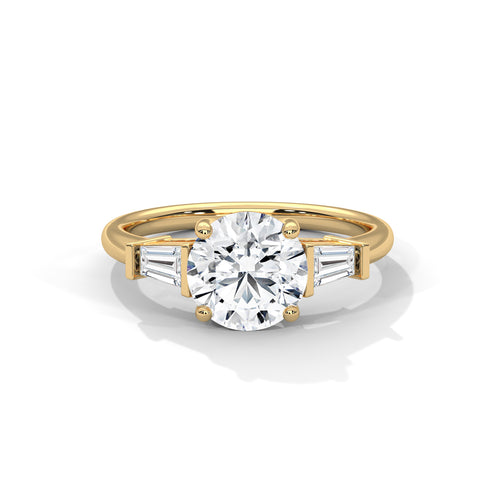 Front view of a solid yellow gold three-stone engagement ring featuring a prominent round brilliant center stone and two tapered baguette side diamonds.