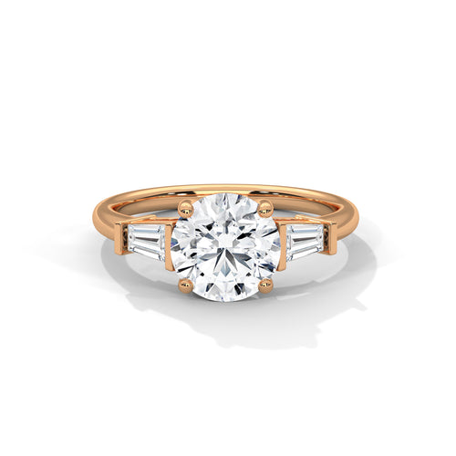 Front view of a warm solid rose gold three-stone engagement ring with a brilliant round center diamond and tailored baguette accents.
