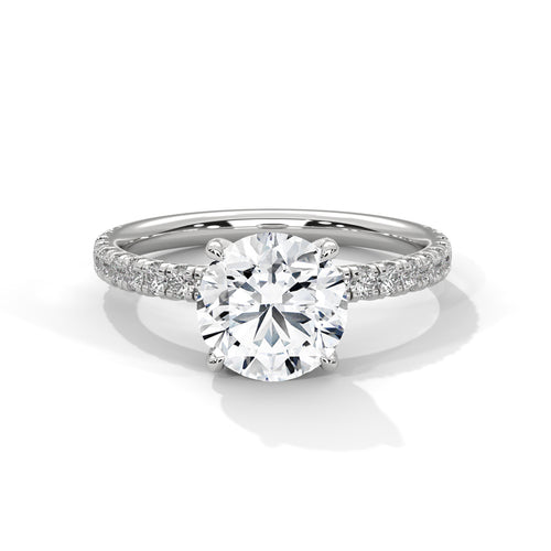 Round brilliant hidden halo pavé engagement ring in white gold, side profile view showing full band