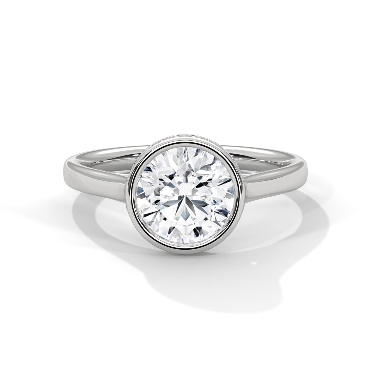 Round brilliant lab-grown diamond engagement ring inside a smooth protective bezel setting on a tapered white gold cathedral band.