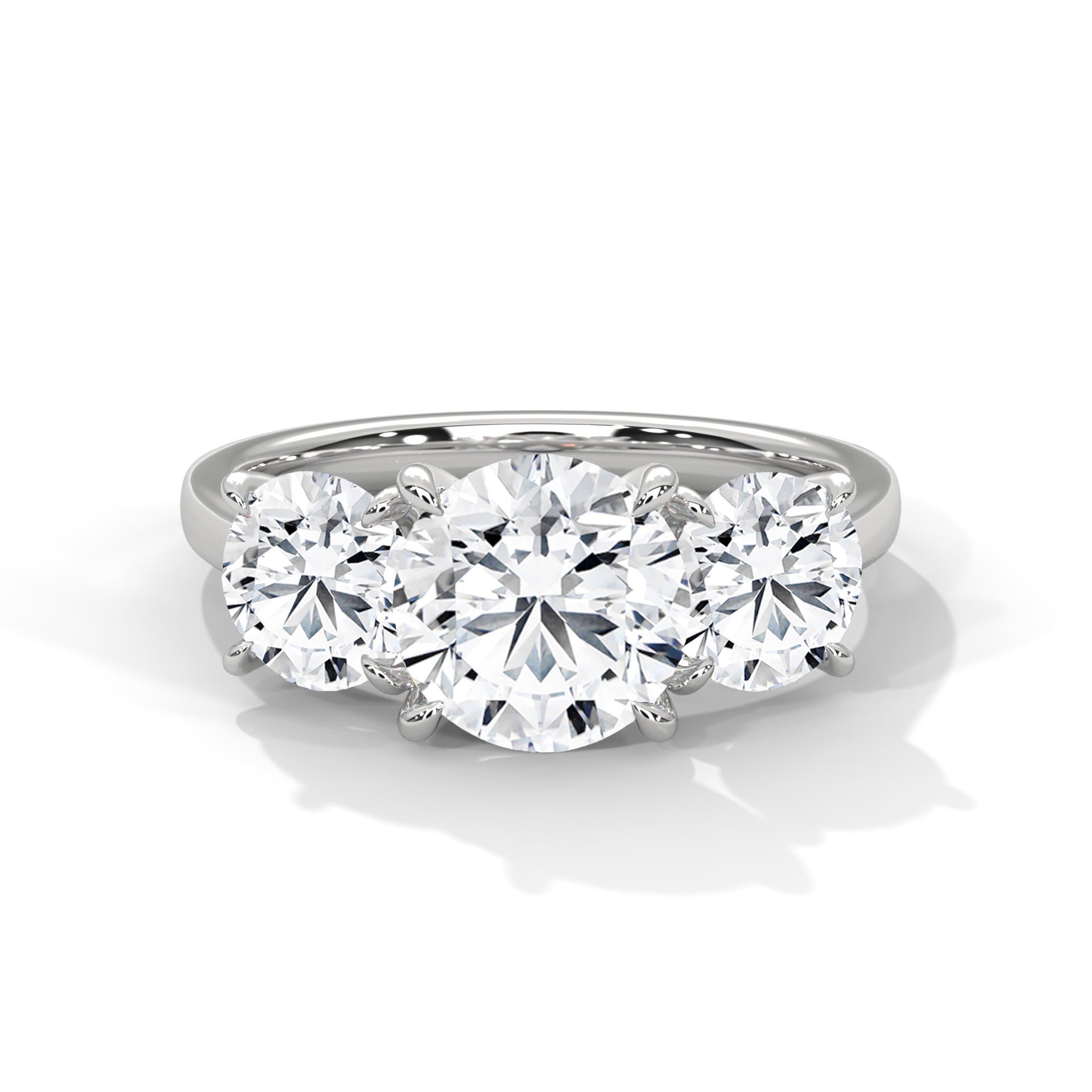 Round brilliant three-stone trilogy engagement ring in white gold, side profile view showing three diamond setting