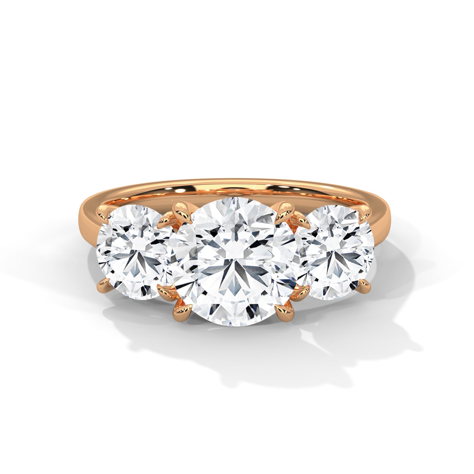 Round brilliant three-stone trilogy engagement ring in rose gold, three-quarter view showing all three stones