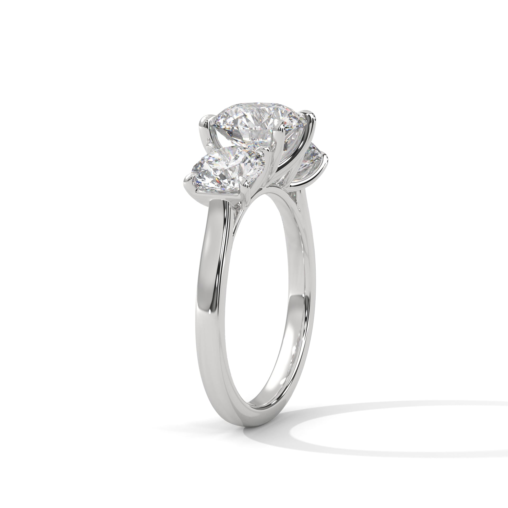Round brilliant three-stone trilogy engagement ring in white gold, angled view showing center and side stones