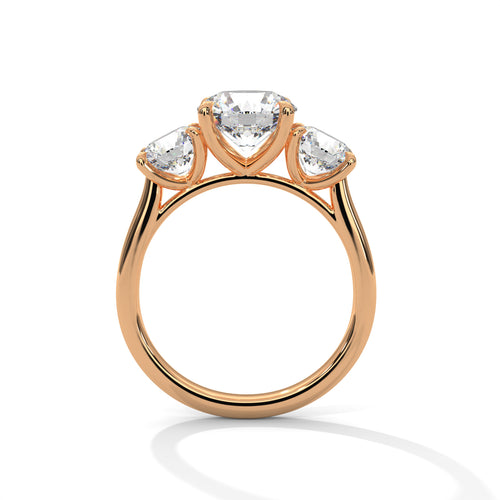 Round brilliant three-stone trilogy engagement ring in rose gold, front view showing three-stone setting and band