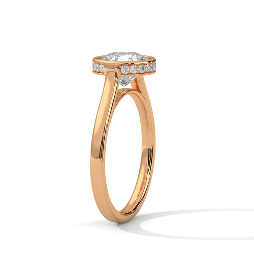 Perspective shot of a round diamond bezel setting on a high-polish rose gold tapered cathedral band.