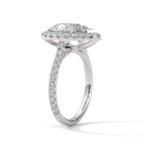 Pear cut bezel-edge floating halo engagement ring in white gold, angled side view showing V-prong head and raised platform halo shelf