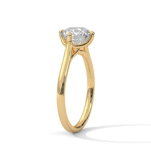 Angled perspective of a round diamond solitaire ring in yellow gold showcasing the cathedral setting.