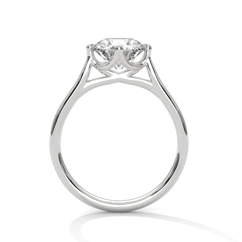 Close-up of a classic round brilliant solitaire engagement ring in white gold worn on a finger.