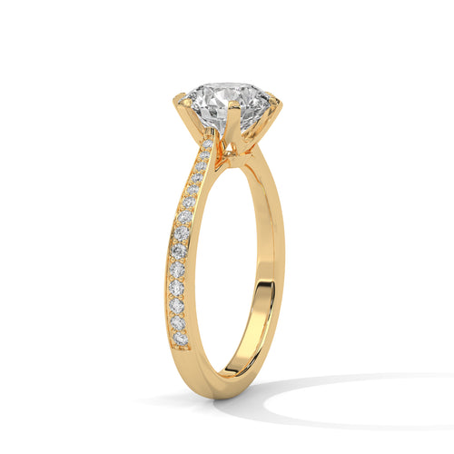 Angled perspective of a round diamond engagement ring in yellow gold showcasing the pavé band.