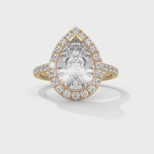 Pear cut bezel-edge floating halo engagement ring in yellow gold, close-up angled view of floating halo and pear stone setting