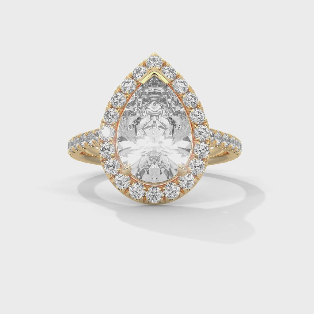 Pear cut bezel-edge floating halo engagement ring in yellow gold, close-up angled view of floating halo and pear stone setting