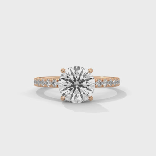 Top-down view of round brilliant hidden halo pavé engagement ring showing stone and pavé setting