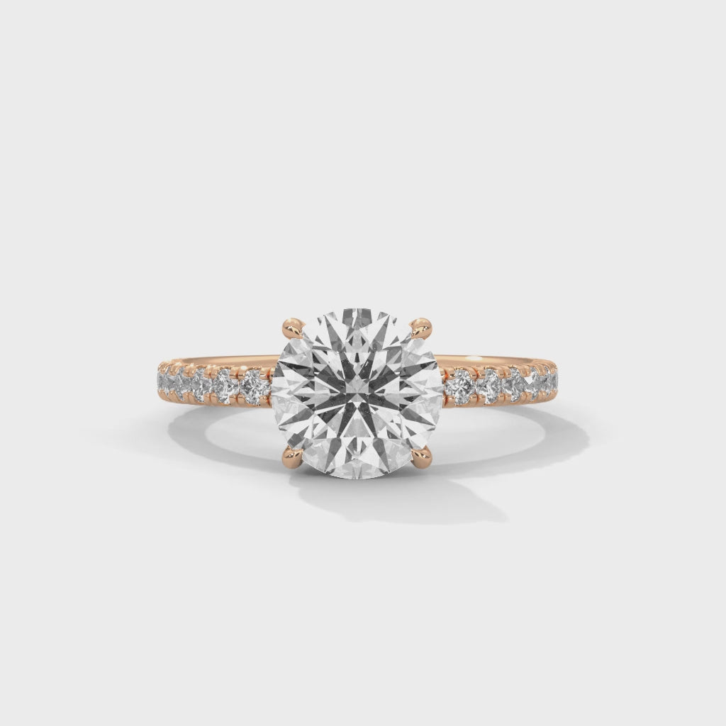Top-down view of round brilliant hidden halo pavé engagement ring showing stone and pavé setting