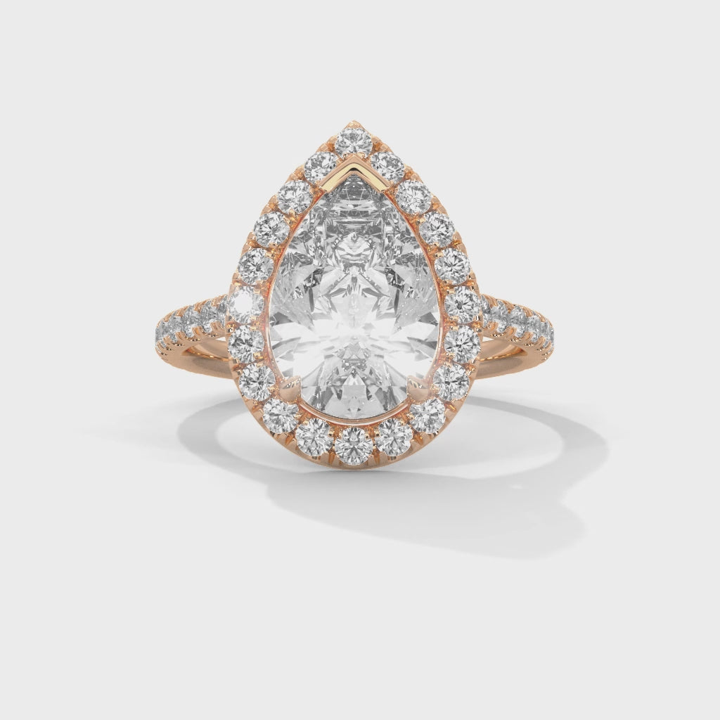Pear cut bezel-edge floating halo engagement ring in rose gold, top-down view of pear brilliant stone and floating halo