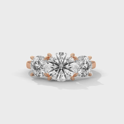 Round brilliant three-stone trilogy engagement ring, top-down view of three round brilliant diamonds