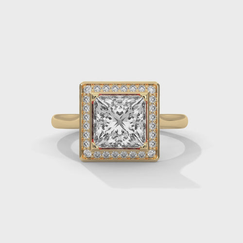 Princess cut elevated square halo engagement ring in yellow gold, close-up top view of square halo and corner prong setting
