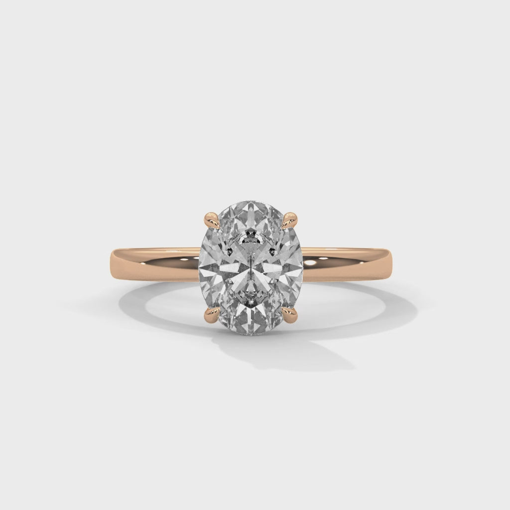 Oval solitaire plain band engagement ring in rose gold, top-down view of oval center stone and plain band