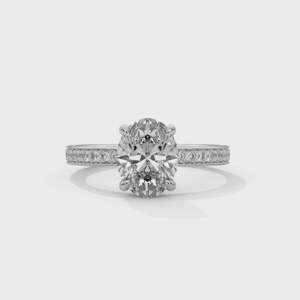 Oval hidden halo micropavé engagement ring in white gold, overhead view of center stone and halo detail
