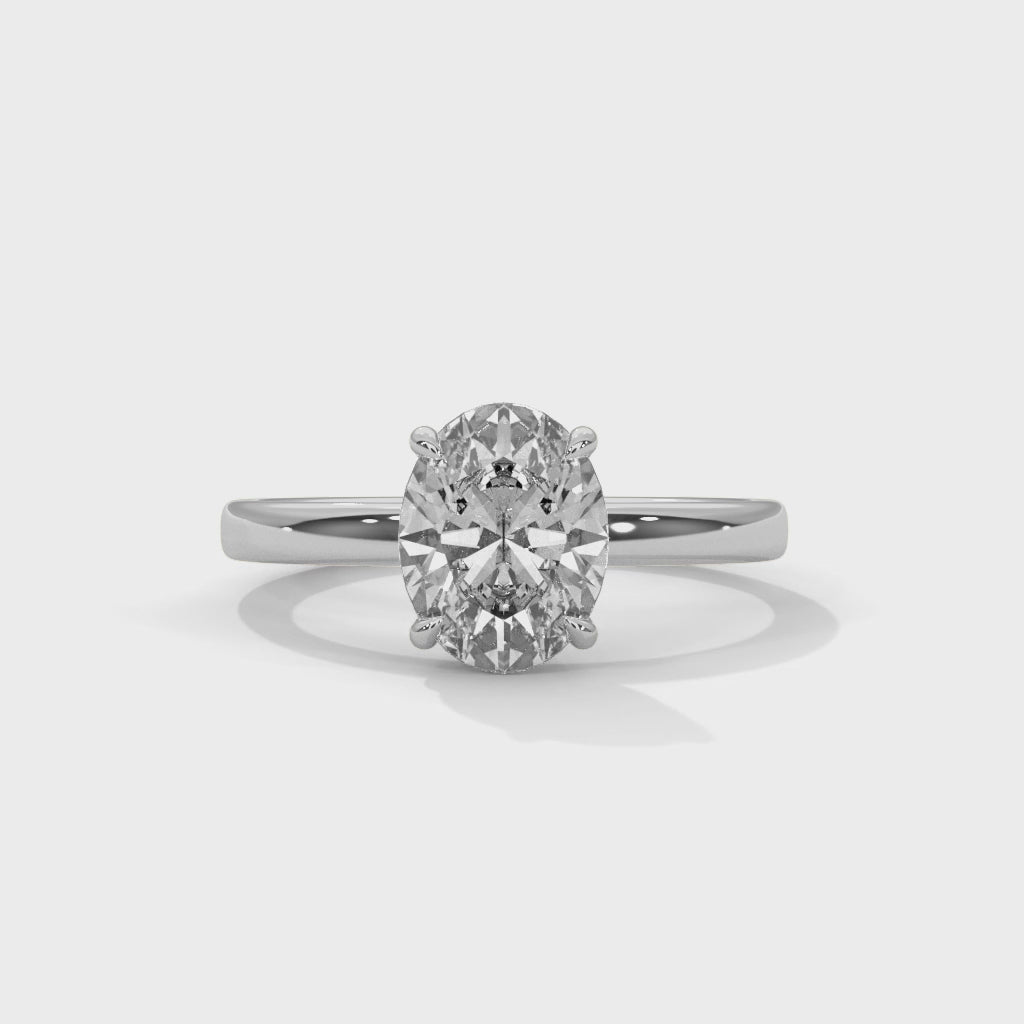 Oval solitaire plain band engagement ring in white gold, overhead view of oval center stone and solitaire setting